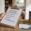 A painter’s quote clipboard sits beside paint samples and a paint tin in a Melbourne home office.
