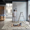 Painters are rolling and cutting in fresh walls inside a Melbourne shop during a commercial repaint.