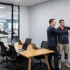 A business manager and painting contractor review the finished walls of an occupied Melbourne office.