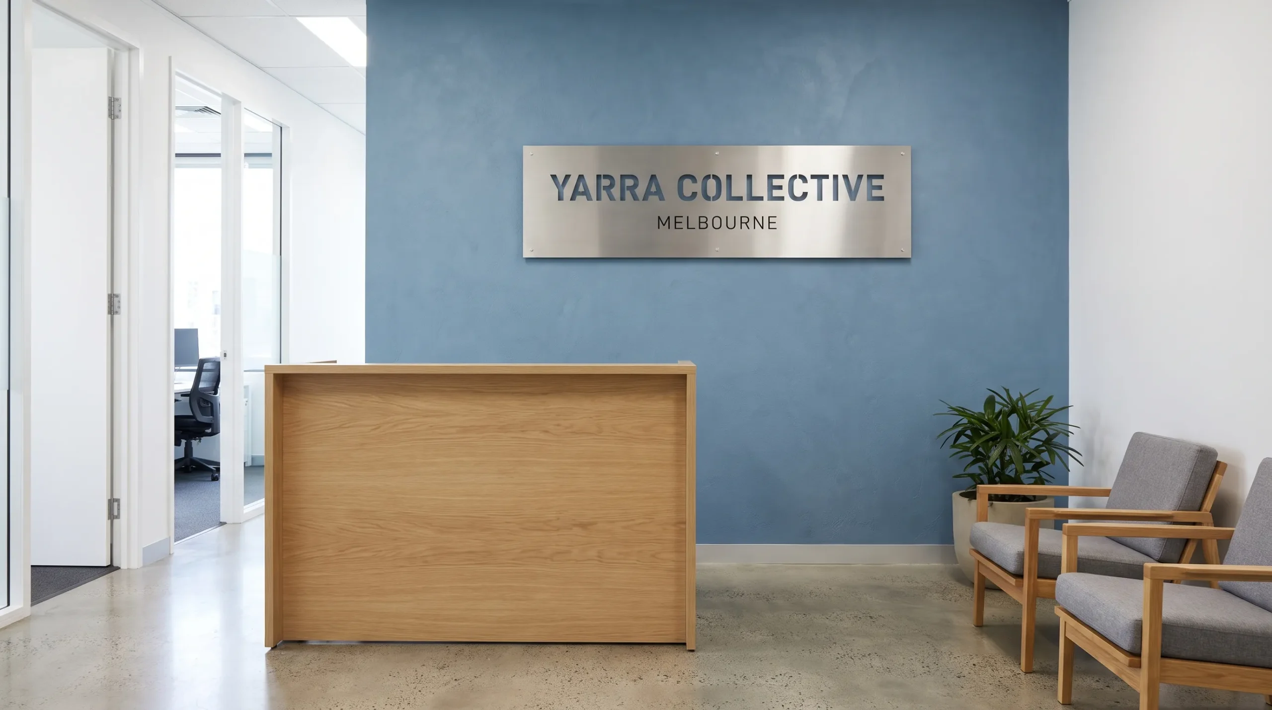 A freshly painted Melbourne reception pairs a muted blue feature wall and business sign with tidy door frames and timber furniture.