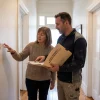 A homeowner and contractor discuss a peeling hallway wall and the repair terms in a painting warranty.