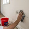 A painter cleans scuff marks from a hallway wall to check whether it needs repainting before a Melbourne home goes on the market.
