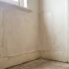 A repaired plaster patch meets an older painted wall in an empty Melbourne rental, showing the kind of surface condition painters assess between tenancies.