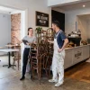 A venue manager and painting contractor review staged room access before a hospitality business reopens.