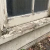 A weathered sash window and peeling timber trim on a Melbourne home show the detailed exterior surfaces painters may need to prepare.